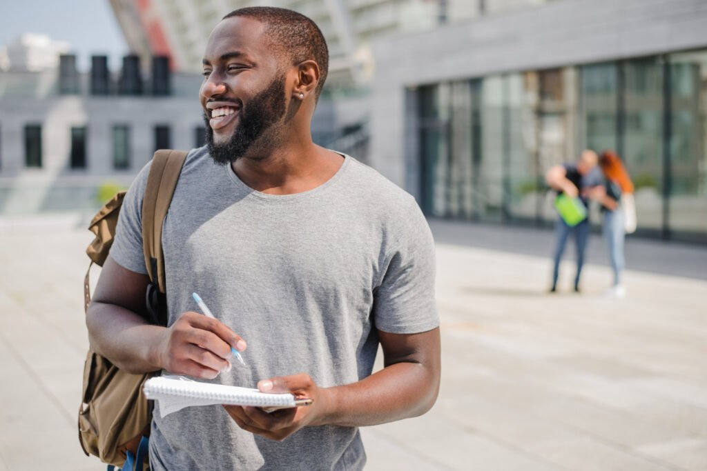 Man holding notebook standing outside
